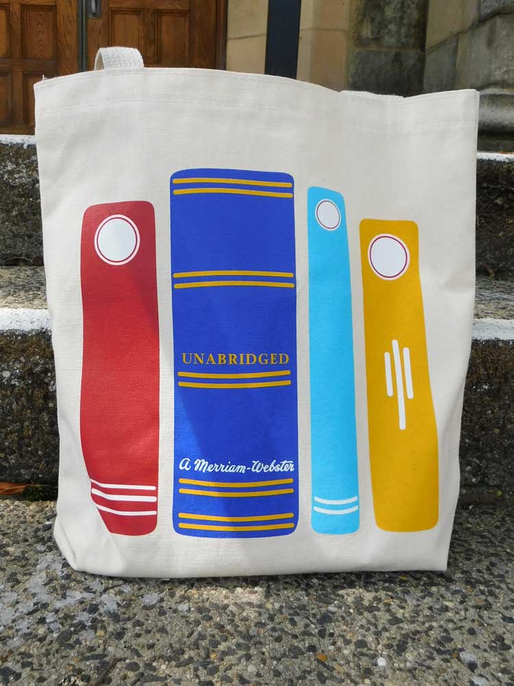 Image of a canvas tote bag with 4 colorful book spines featuring Merriam-Webster branding.
